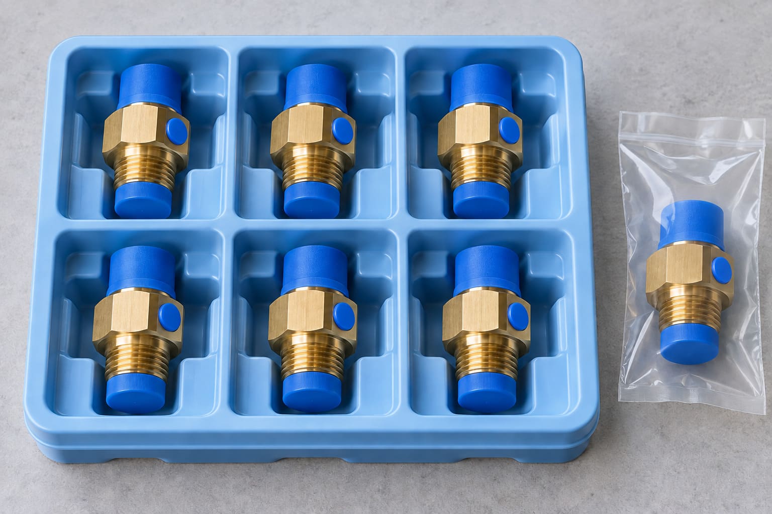 Illustration of capped brass connectors in separate blue tray compartments, with one fitting in a clear protective bag.